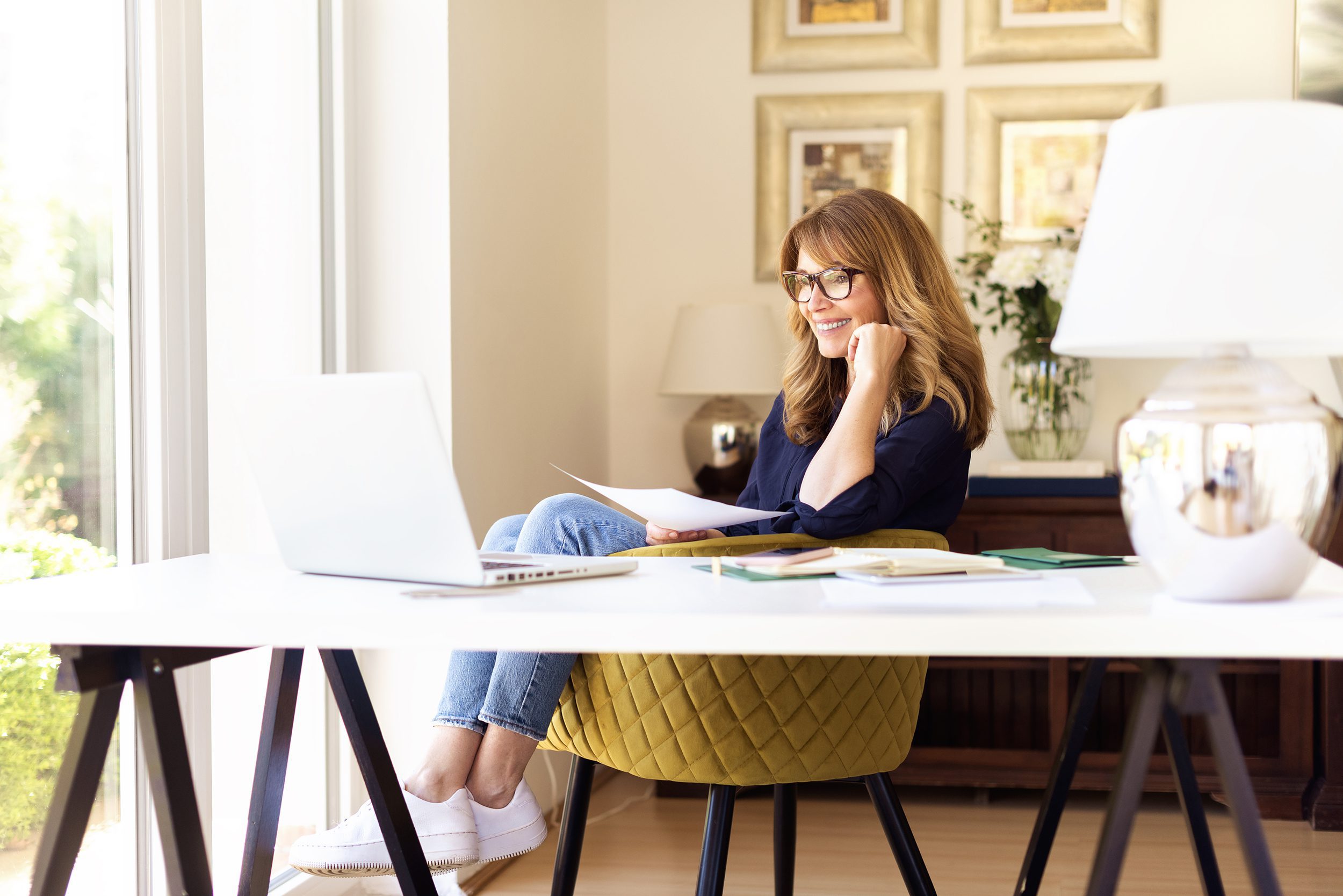 Shot of happy smiling businesswoman using her laptop while working at home. Home office.