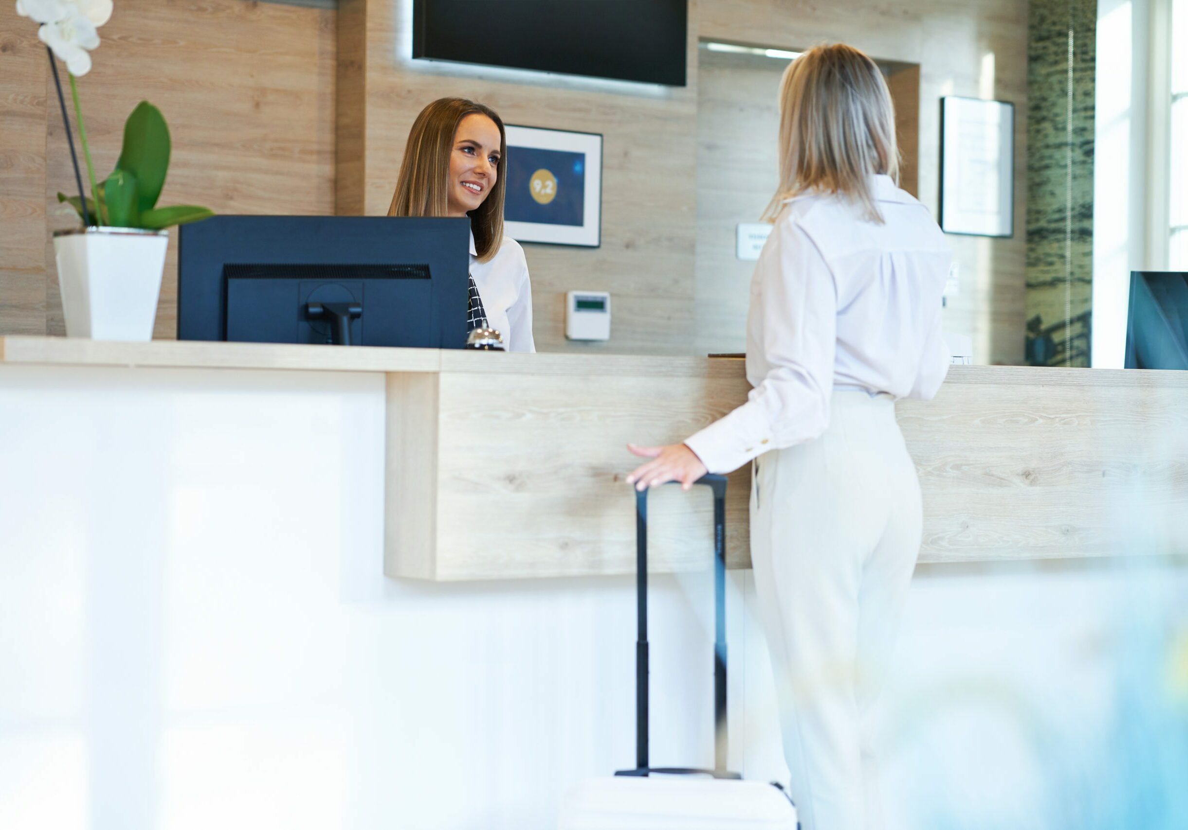 Picture of receptionist and businesswoman at hotel front desk